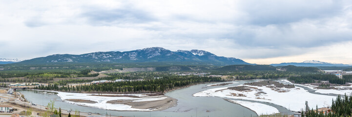 The city of Whitehorse with the Yukon River seen in the spring time when there is still snow and...