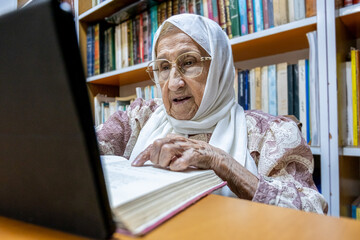 Arabic muslim woman using laptop for reading E-books nad surfing internet