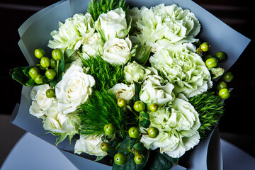 top view on handmade elegant bouquet of big white roses and fresh greenery