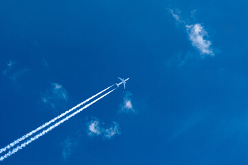 Airplane streaking across the blue sky