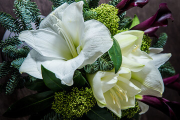 closeup exquisite bouquet made from white lily, purple calla, and fresh greenery