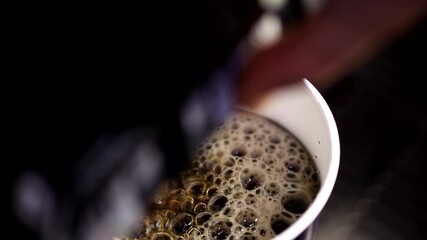 Close up 4k changing focus shot of man hand using automatic drink machine to pour soda water with bubbles in plastic cup
