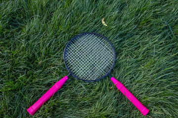 Isolated small badminton tennis rackets laying on grass ground. Rackets on paver patio floor. - 357960450