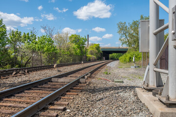Curved train tracks in industrial area with blue sky background. Locomotive  train tracks under a road overpass. - 357960629