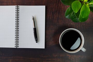 Top view from above of Blank open notebook and coffee on wood table background. 