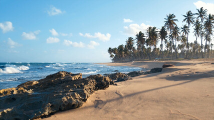 Sunset on the Atlantic Ocean. Waves breaking on stones. Beautiful wild beach on a tropical island....