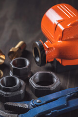 Plumbing. Different wrenches, pipe, tube, fittings and connectors on a wooden rustic table.