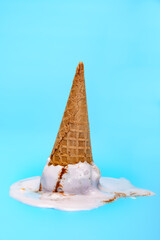 sweet potato flavor ice cream cone upside down and melted on blue background