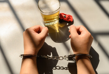 arrested drunk driver in a jail with handcuffs