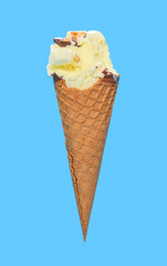 side view fresh pineapple ice cream cone with couple of bites on blue background