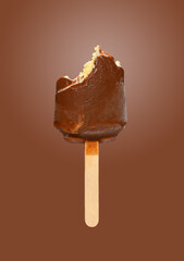 half eaten chocolate outer popsicle on brown background