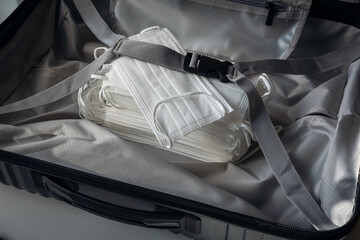 A mask in a suitcase. The concept image of the travel season is to watch out for virus attacks.