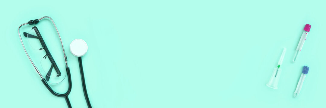 stethoscope and eyeglass lying on a green background. The concept of medical equipment instrument.