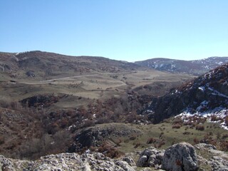 Former fortress on a hilltop stretching toward mountain in rural area
