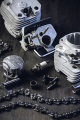 Chainsaw engine parts. Cylinder, piston, rings, pin, spark plug. Garden equipment service and repair