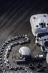 Chainsaw engine parts. Cylinder, piston, rings, pin, spark plug. Garden equipment service and repair