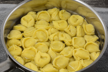 Close up of boiled cheese tortellini in stainless steel cooking pan