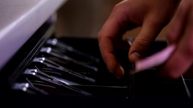 Close up shot of male cashier hand opening cash register drawer with key taking counting money banknotes fast