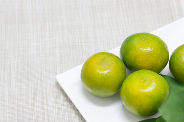 Tangerine on a white plate with a cloth background