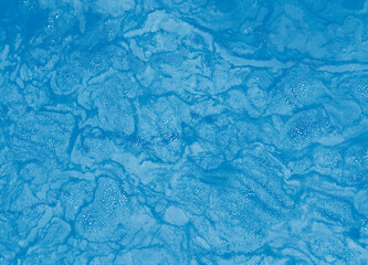 Soap bubbles floating on the blue water