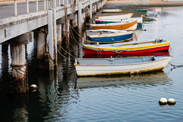 Fototapeta na wymiar Row of old small boats moored to jetty, Victoria, Australia