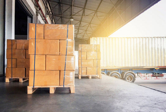 Packaging Boxes Wrapped Plastic Film on Pallets Loading into Shipping Cargo Container. Supply Chain. Trucks Parked Loading at Dock Warehouse. Shipment Logistics. Cargo Freight Truck Transport.