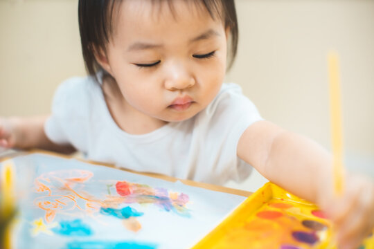 Cute Asian Little Girl Is Painting The Color With Fully Happiness Moment , Concept Of Art And Education For Kid. Closed Up Kid Practice Paiting For Homeschooling.Lovely Asian Girl Drawing