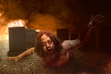 Scary zombie with blood and wound on his body crawling with an explosion