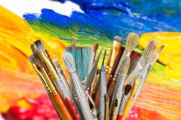 A different set of artist paint brushes on colored background