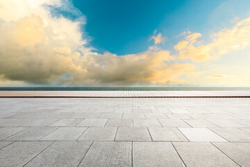 Empty square floor and lake under blue sky.