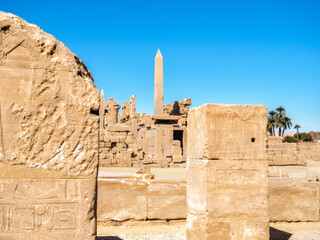 Ancient ruins under clear blue sky, medium view. Ruins of Karnak temple. Photographed in Luxor, Egypt. Selective soft focus. Blurred background