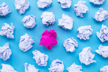 Naklejka premium White with pink crumpled paper balls on a blue background.