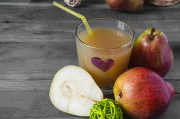 a glass of pear juice with a colored heart and juicy pears on a black and white background Kopi space
