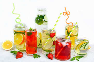 Summer homemade refreshing drinks of lemon, lime, strawberry, orange, mint on a white background. Detox, healthy eating, fitness drinks. Travel concept.Copy space