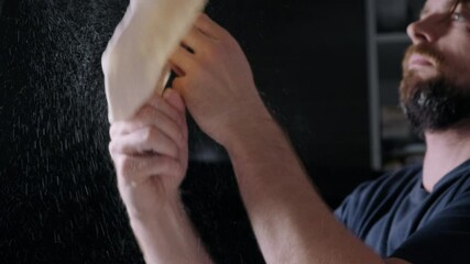 Young man throwing pizza dough in the air
