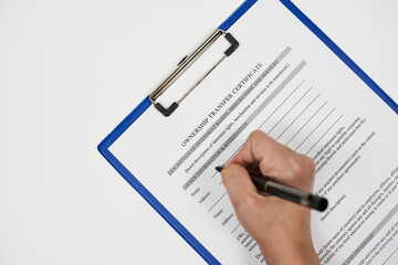A person filling ownership transfer certificate document