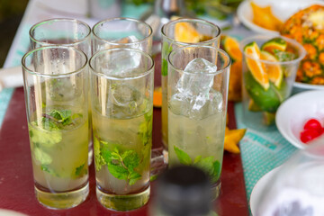 Mojito cocktail with lime and mint in glasses on a beach