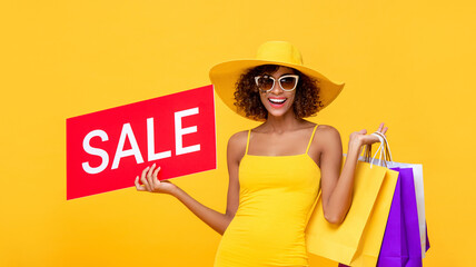 Surprised fashionable curly hair woman carrying shopping bags with red sale sign on yellow...