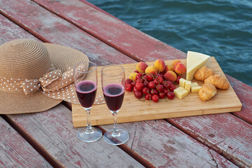 Two glasses of red wine, served outdoor with fruits