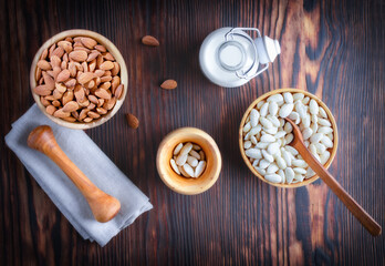 Almond milk, peeled and untreated almonds, ingredients for cooking. Nuts in a wooden bowl. Photo, image.