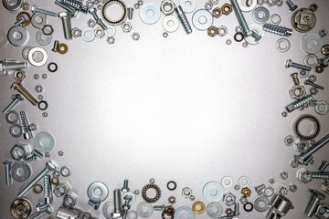frame background. chrome-plated bolts and nuts on gray metal surface with copy space