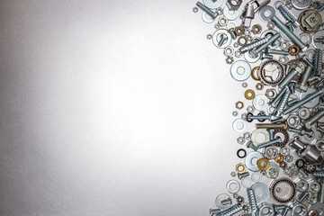 different sizes of screws, bolts and nuts for home repair work on metallic grey background