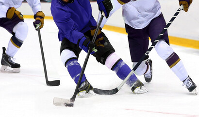 Ice hockey player dribbling puck on rink