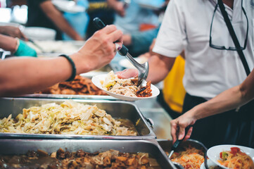 The hands of the poor receive food that volunteers share to alleviate hunger: the concept of donating food to the poor