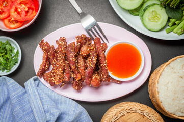 Deep fried sun dried pork serve with chili sauce, vegetable and sticky rice.