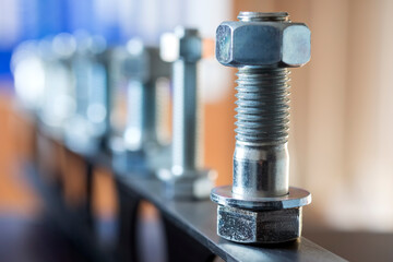 View of the bolts and nuts (fasteners). A bolt is a form of threaded fastener with an external male thread. Bolts are very closely related to screws. Bolts are often used to make a bolted joint. - obrazy, fototapety, plakaty