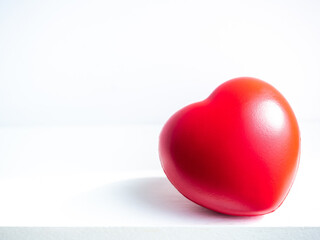 Red heart. Close-up big red heart ball on white clean table on white background.