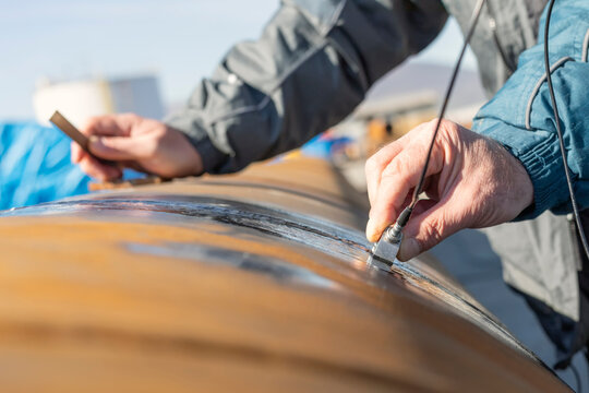 Inspector is ultrasonic testing to pipe welds. Ultrasonic Testing (UT) uses high frequency sound waves. (typically in the range between 0.5 and 15 MHz) to conduct examinations and make measurements.