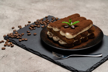 Classic tiramisu dessert on ceramic plate on concrete background