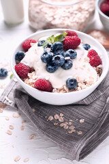 Breakfast, oatmeal with blueberry and raspberry on white bowl in the morning.